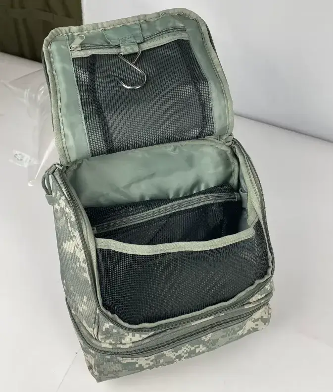 Interior of a camouflage-patterned toiletry bag, open with a hook and mesh pockets visible.