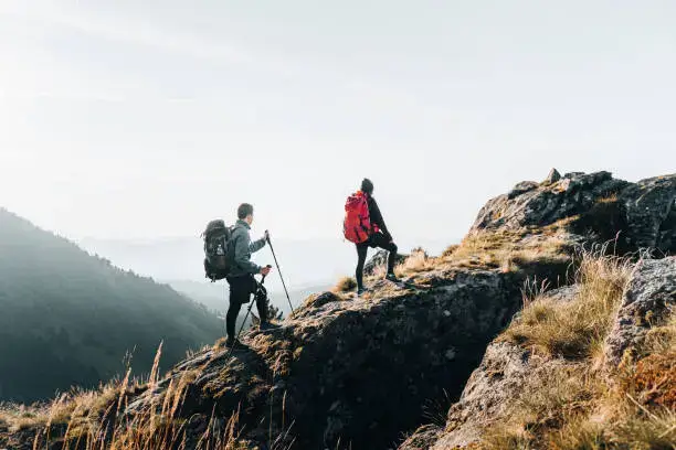 A young couple backpack up a mountain summit, Baden-Württemberg
