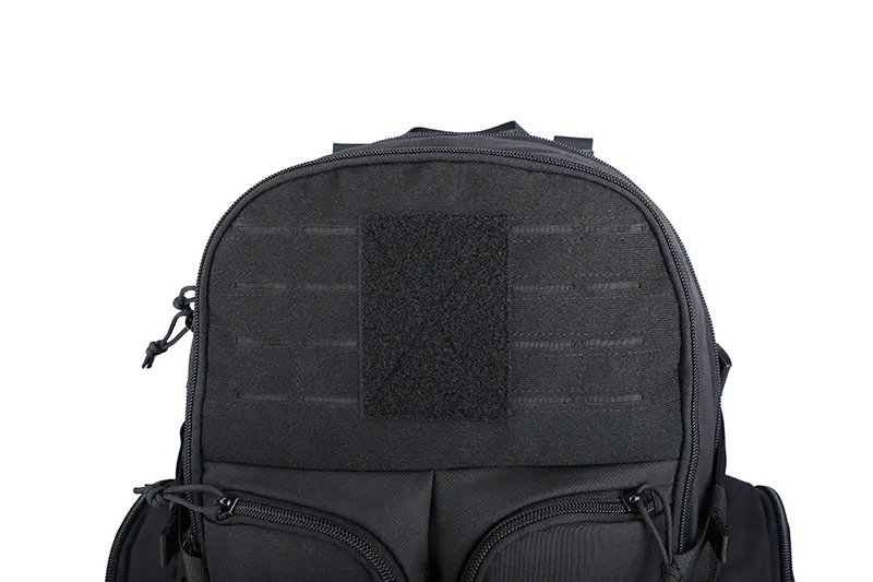 Close-up of black tactical backpack top with MOLLE webbing and Velcro patch.