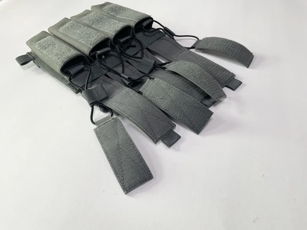 Gray tactical magazine placard with four elastic mag pouches and adjustable bungee retention straps.