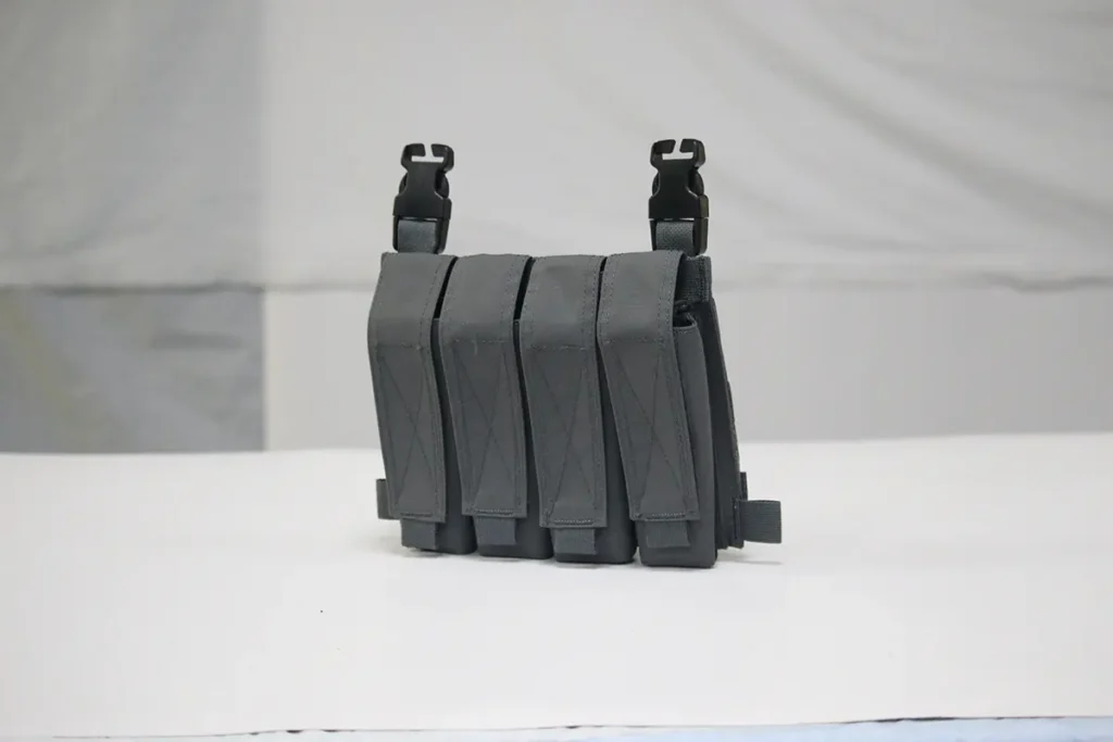 Gray tactical placard with four magazine pouches and quick-release buckles for plate carrier attachment.