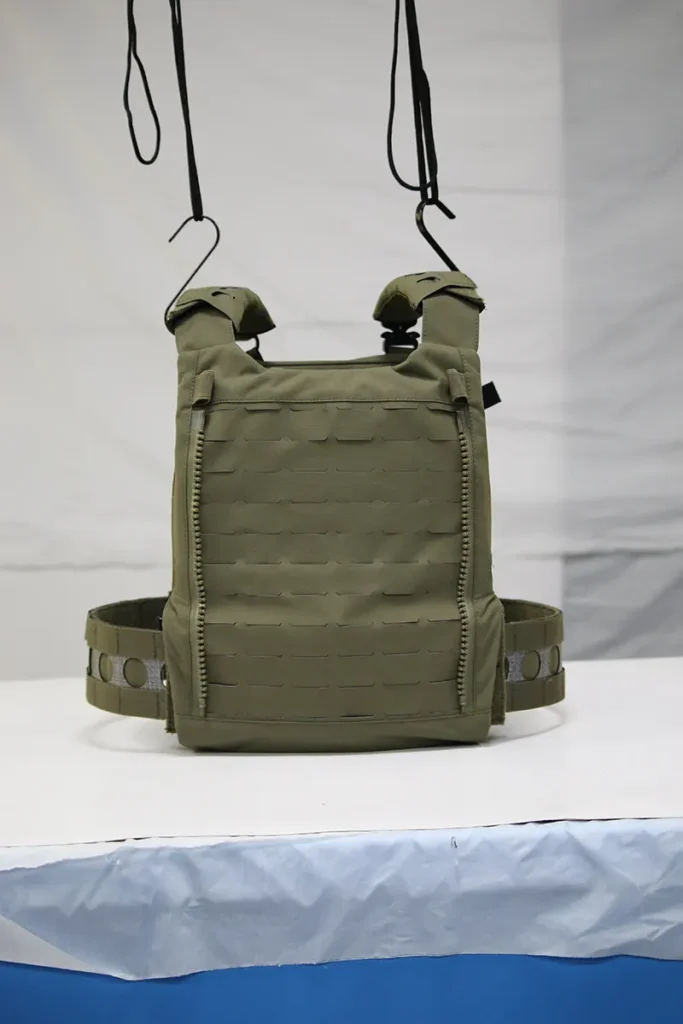 Green tactical vest with MOLLE webbing and adjustable straps