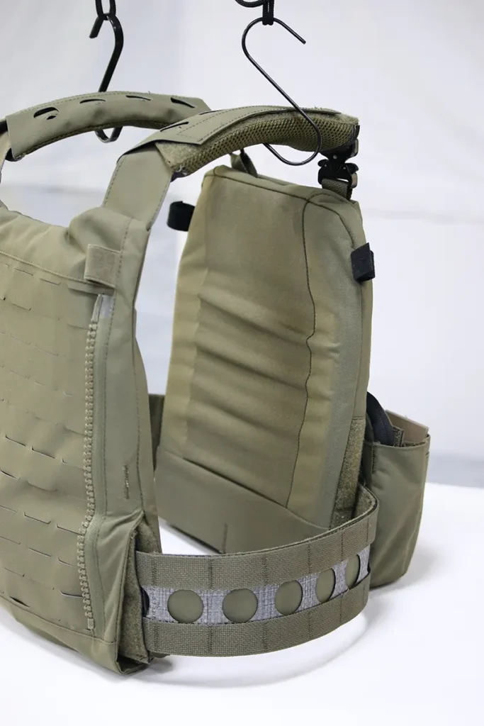 Green tactical vest with MOLLE webbing and padded shoulder straps