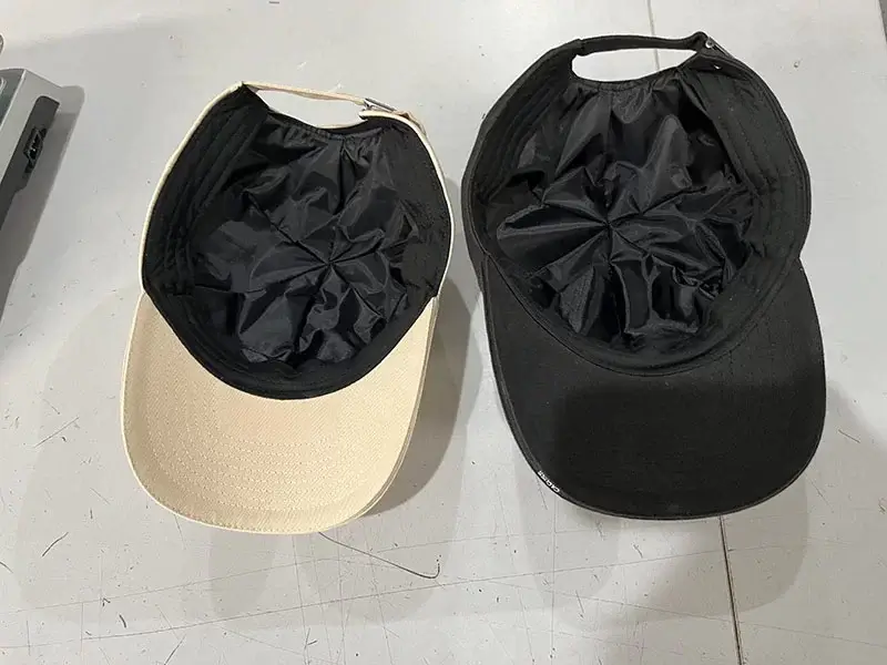 Two tactical caps, one beige and one black, placed with their insides visible